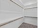 Walk-in closet featuring wood shelving, ample storage space, and stylish wood-look flooring at 26079 S 228Th St, Queen Creek, AZ 85142