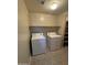 Laundry room with washer, dryer, shelving and tile flooring at 3330 S Gilbert Rd # 1003, Chandler, AZ 85286