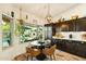 Breakfast nook with views of the pool and fireplace through a picture window, dark cabinets, and modern lighting at 3921 W Sheffield Ave, Chandler, AZ 85226
