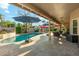 Backyard pool with a covered patio area for dining and relaxing, complete with umbrellas for shade and a built-in grill at 3921 W Sheffield Ave, Chandler, AZ 85226