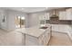 Modern kitchen with white cabinets, quartz countertops and a large island and stainless steel appliances at 4119 S 176Th Dr, Goodyear, AZ 85338