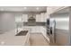Modern kitchen featuring white cabinets, stainless steel appliances, and a stylish gray backsplash at 4119 S 176Th Dr, Goodyear, AZ 85338