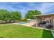 Spacious backyard featuring a large pool, covered patio with outdoor seating, and lush green lawn at 4208 E Windsor Ave, Phoenix, AZ 85008