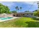 Expansive backyard featuring a well-maintained lawn, sparkling pool, covered patio, and mature palm trees at 4208 E Windsor Ave, Phoenix, AZ 85008