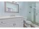 Updated bathroom includes a white vanity, a frameless shower, and light blue walls, creating a fresh atmosphere at 4208 E Windsor Ave, Phoenix, AZ 85008