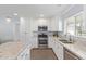 Updated kitchen boasts stainless steel appliances, granite countertops, tile backsplash, and lots of white cabinetry at 4208 E Windsor Ave, Phoenix, AZ 85008