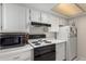 Bright kitchen featuring white cabinets, a black oven, and a microwave at 461 W Holmes Ave # 224, Mesa, AZ 85210