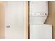 A side-by-side white washer and dryer with a door next to it at 461 W Holmes Ave # 224, Mesa, AZ 85210
