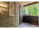 Outdoor patio with gray textured walls, ceramic tiled floors, a window, a wooden railing and door at 461 W Holmes Ave # 224, Mesa, AZ 85210