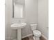 Powder room with pedestal sink, framed mirror, and low-flow toilet at 4813 N 177Th Ln, Goodyear, AZ 85395