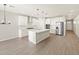 Open kitchen and living area with an island with stainless steel appliances and modern light fixtures at 4813 N 177Th Ln, Goodyear, AZ 85395