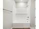 A clean, white bathroom featuring a bathtub with subway tile surround and a shelf at 4819 N 177Th Ln, Goodyear, AZ 85395