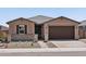 Single-story home featuring desert landscaping, a two-car garage, and charming stone accents at 4819 N 177Th Ln, Goodyear, AZ 85395