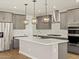 Modern kitchen boasts stainless steel appliances and a large island with pendant lighting at 4819 N 177Th Ln, Goodyear, AZ 85395