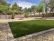 Landscaped backyard featuring an artificial lawn, firepit, decorative stone, and privacy fence at 665 W Beechnut Dr, Chandler, AZ 85248