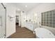 Well-lit bathroom featuring dual vanities, an enclosed glass shower, and a modern freestanding tub at 665 W Beechnut Dr, Chandler, AZ 85248