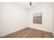 Simple bedroom with neutral walls, ceiling fan, window and wood flooring at 665 W Beechnut Dr, Chandler, AZ 85248