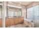 Luxurious bathroom with stone walls, double sinks, granite countertops, and a bathtub at 7538 E Tuckey Ln, Scottsdale, AZ 85250