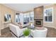 Elegant living room with fireplace, white furniture, and natural light from shuttered windows at 7538 E Tuckey Ln, Scottsdale, AZ 85250