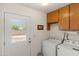 Well-lit laundry room with washer, dryer, cabinets, and backyard access at 8315 E Lobo Ave, Mesa, AZ 85209