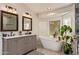 Bright bathroom features dual sinks, marble countertops, and a modern freestanding bathtub with abundant light at 851 N Citrus Cove --, Mesa, AZ 85213