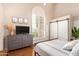 Cozy bedroom featuring modern furnishings, a large arched window with plantation shutters, and hardwood floors at 851 N Citrus Cove --, Mesa, AZ 85213