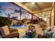 Relaxing covered patio features comfortable seating, ceiling fans, and a view of the pool with rock waterfall at 911 E Desert Inn Dr, Chandler, AZ 85249