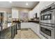 Bright kitchen featuring white cabinets, stainless steel appliances, and a decorative tile backsplash at 911 E Desert Inn Dr, Chandler, AZ 85249