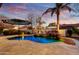 Backyard pool with a rock waterfall feature, travertine tile, and a shaded umbrella area at 911 E Desert Inn Dr, Chandler, AZ 85249