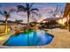 Beautiful backyard pool area featuring a rock waterfall, palm trees, and a lounge area at 911 E Desert Inn Dr, Chandler, AZ 85249