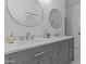 Bright bathroom with modern dual sinks, round mirrors and a white countertop at 9733 W Hedge Hog Pl, Peoria, AZ 85383
