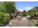 Backyard fire pit area with seating and lush tropical landscaping at 9733 W Hedge Hog Pl, Peoria, AZ 85383