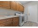 Functional laundry room with a sink, washer, dryer, and ample cabinet space at 9733 W Hedge Hog Pl, Peoria, AZ 85383