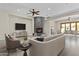 Cozy living room with stone fireplace, wood floors, and a view of the patio at 9733 W Hedge Hog Pl, Peoria, AZ 85383