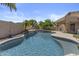 Beautiful backyard pool featuring a rock waterfall and lush greenery at 9733 W Hedge Hog Pl, Peoria, AZ 85383