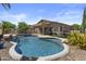 Inviting backyard pool with a waterfall feature and lush landscaping at 9733 W Hedge Hog Pl, Peoria, AZ 85383