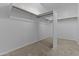A large, empty walk-in closet with installed shelving and neutral carpet at 9733 W Hedge Hog Pl, Peoria, AZ 85383