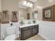 The powder room has a sleek vanity and decorative wainscoting at 10749 E Nido Ave, Mesa, AZ 85209