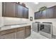 The laundry area has upper cabinets and modern machines at 10749 E Nido Ave, Mesa, AZ 85209