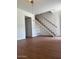 Open-concept living room with staircase, featuring wood laminate flooring at 2533 W Rose Ln # A8, Phoenix, AZ 85017