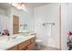 Bright bathroom with light wood cabinets, a large mirror and neutral tile flooring at 3713 E Encinas Ave, Gilbert, AZ 85234