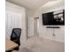 Home office featuring a large flat-screen tv, a desk and neutral walls and carpeting at 3713 E Encinas Ave, Gilbert, AZ 85234