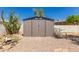 Metal outdoor shed in the backyard on a gravel lot with cacti and a chair at 5410 E Duncan St, Mesa, AZ 85205