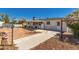 Large backyard featuring a covered patio, walking path, and vibrant greenery at 5410 E Duncan St, Mesa, AZ 85205
