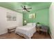 Cozy bedroom with green accent wall, ceiling fan, and window at 5410 E Duncan St, Mesa, AZ 85205
