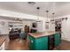 Open-concept kitchen with an eat-in island and mini fridge, seamlessly connected to the adjacent living room at 5410 E Duncan St, Mesa, AZ 85205