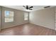 Bedroom with wood flooring, ceiling fan, and natural light from two windows at 129 S 198Th Dr, Buckeye, AZ 85326