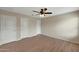 Bedroom with wood flooring, ceiling fan, and three doors at 129 S 198Th Dr, Buckeye, AZ 85326