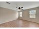 Primary bedroom with wood flooring, ceiling fan, and natural light from two windows at 129 S 198Th Dr, Buckeye, AZ 85326