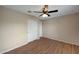 This bedroom offers wood floors, a ceiling fan, neutral paint, and a closet with sliding doors at 129 S 198Th Dr, Buckeye, AZ 85326